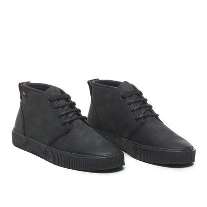 A pair of Sanjo mid-top leather desert boots in black with black laces and a durable rubber sole, styled with a sleek and versatile design.