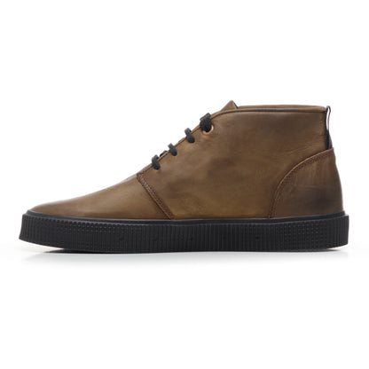 A side view of a Sanjo mid-top leather desert boot in brown with black laces and a durable black rubber sole, styled with a sleek and versatile design.